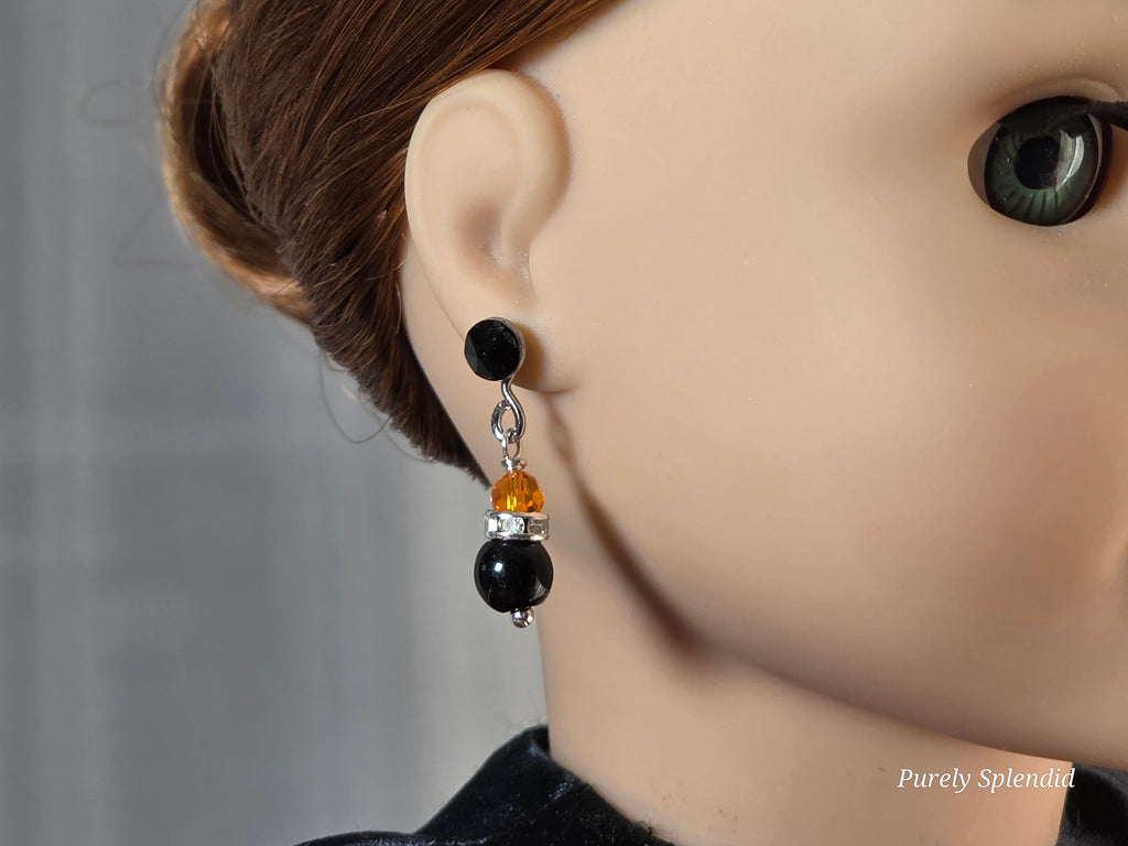 Doll wearing a pair of Sparkling Halloween Earrings and Jet Black 2mm Studs