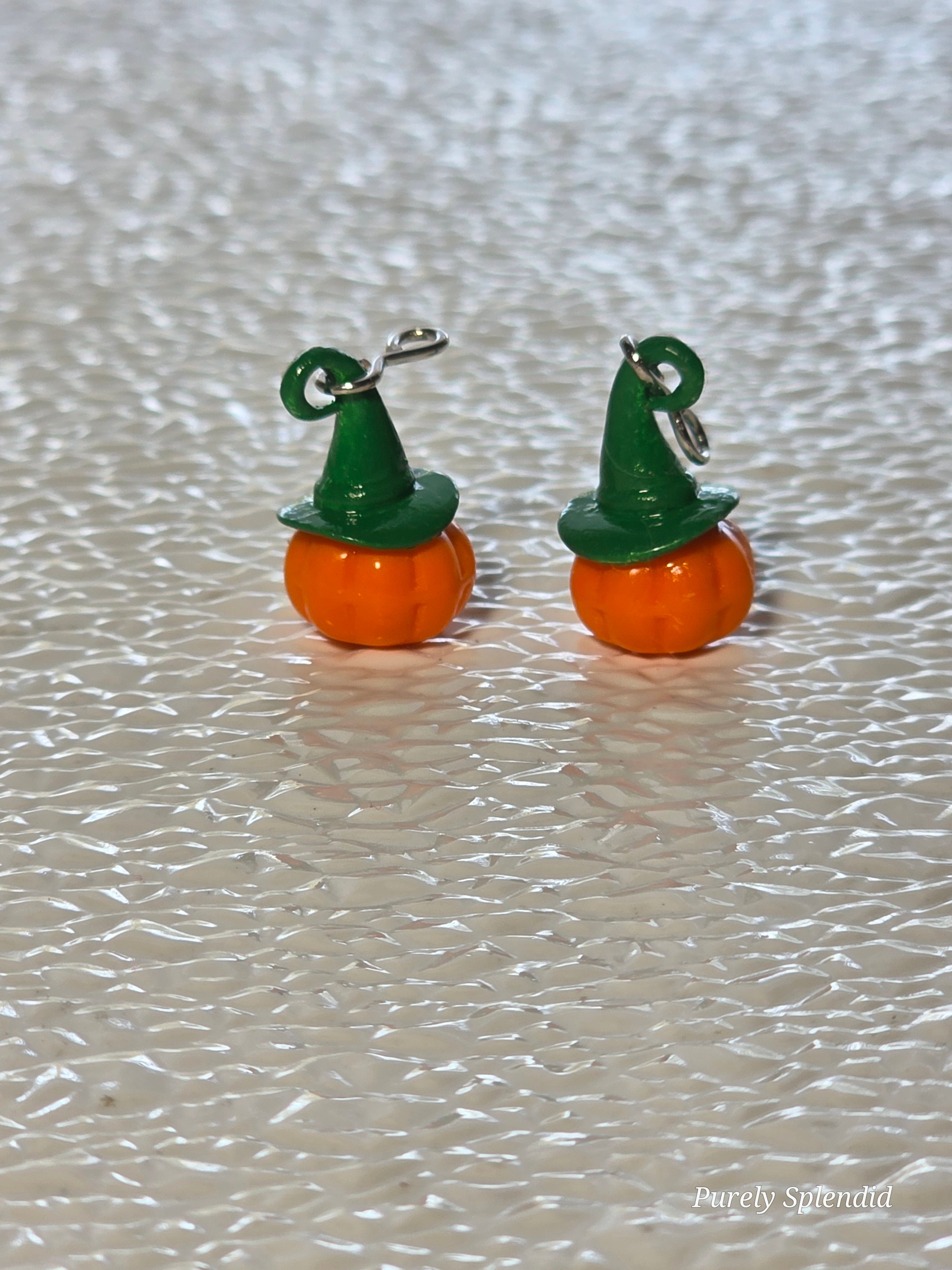 pair of orange pumpkin earrings with green witches hat