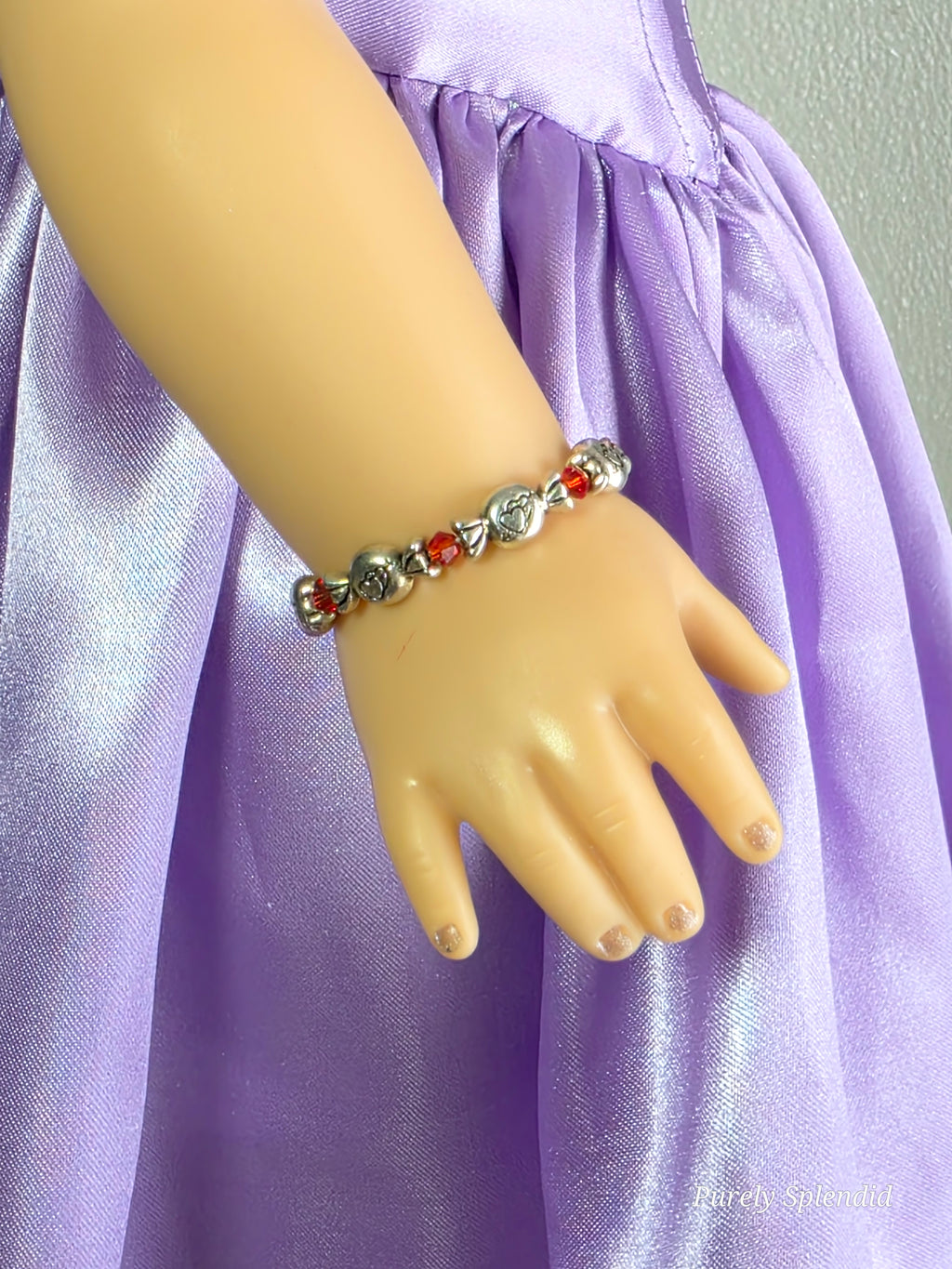 18 inch doll wearing Valentine candy bracelet with hearts on the candies