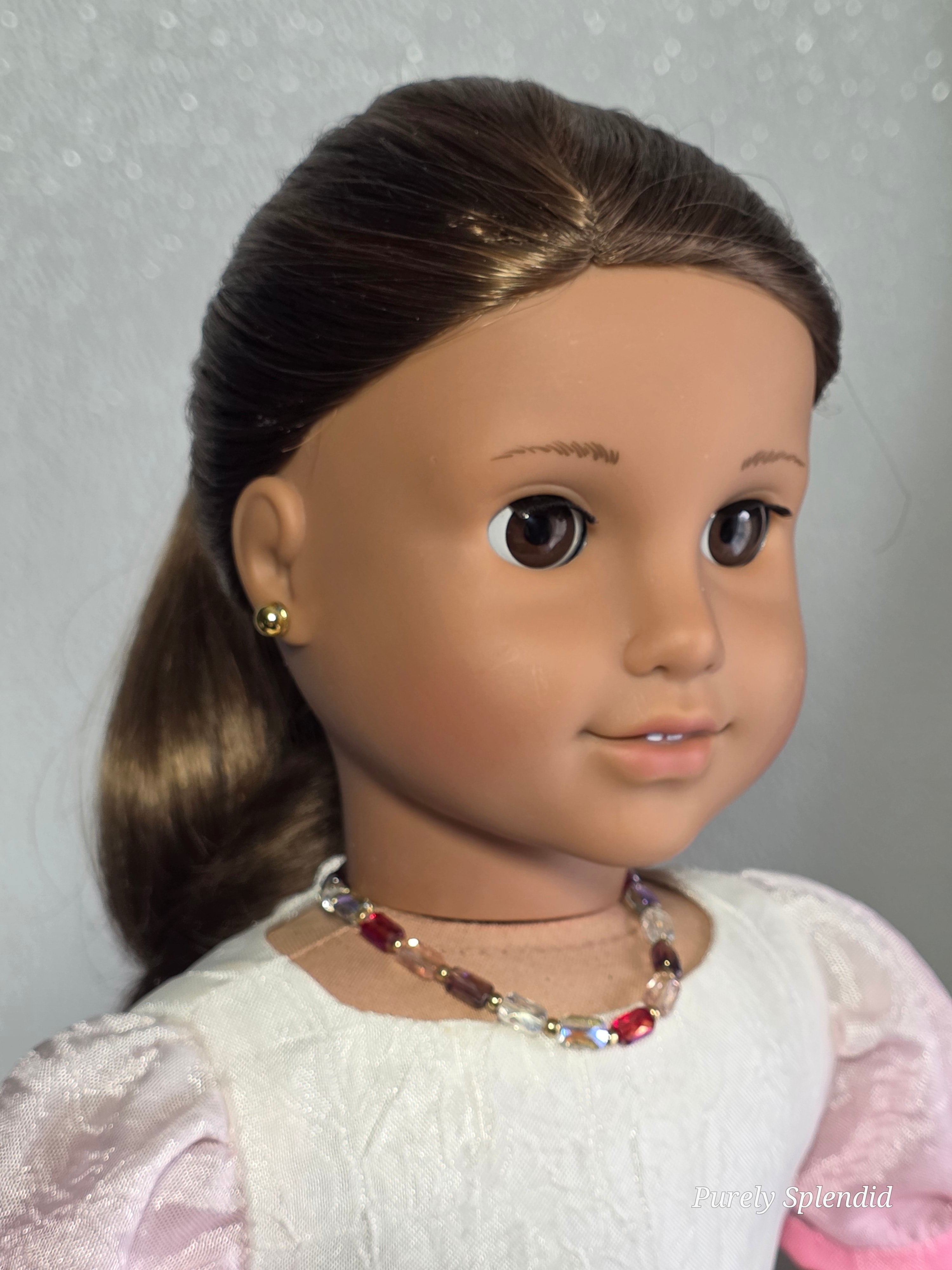 18 inch doll wearing multi-colored crystal necklace