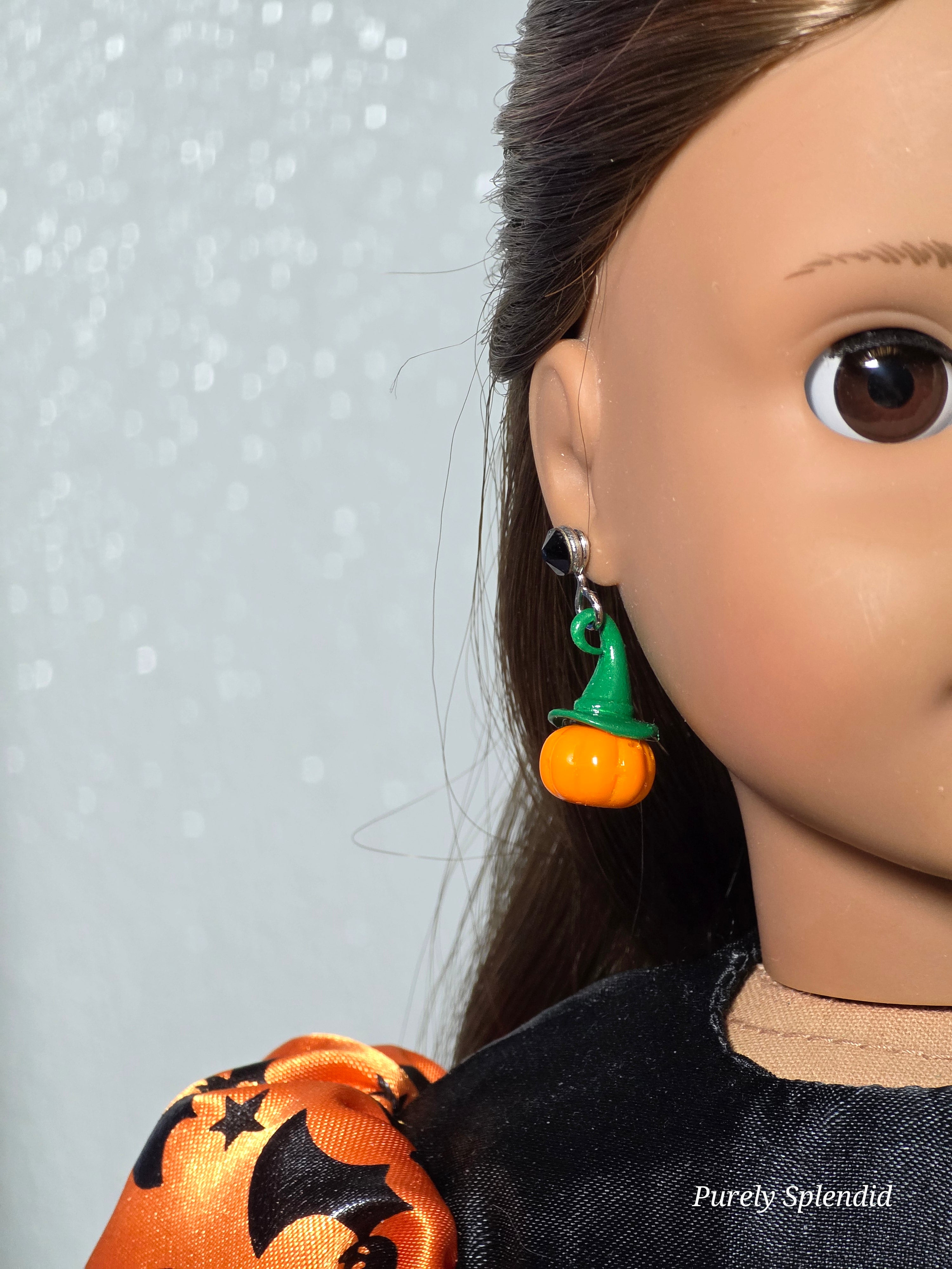 Pumpkin earrings with a green witches hat worn by an 18 inch doll