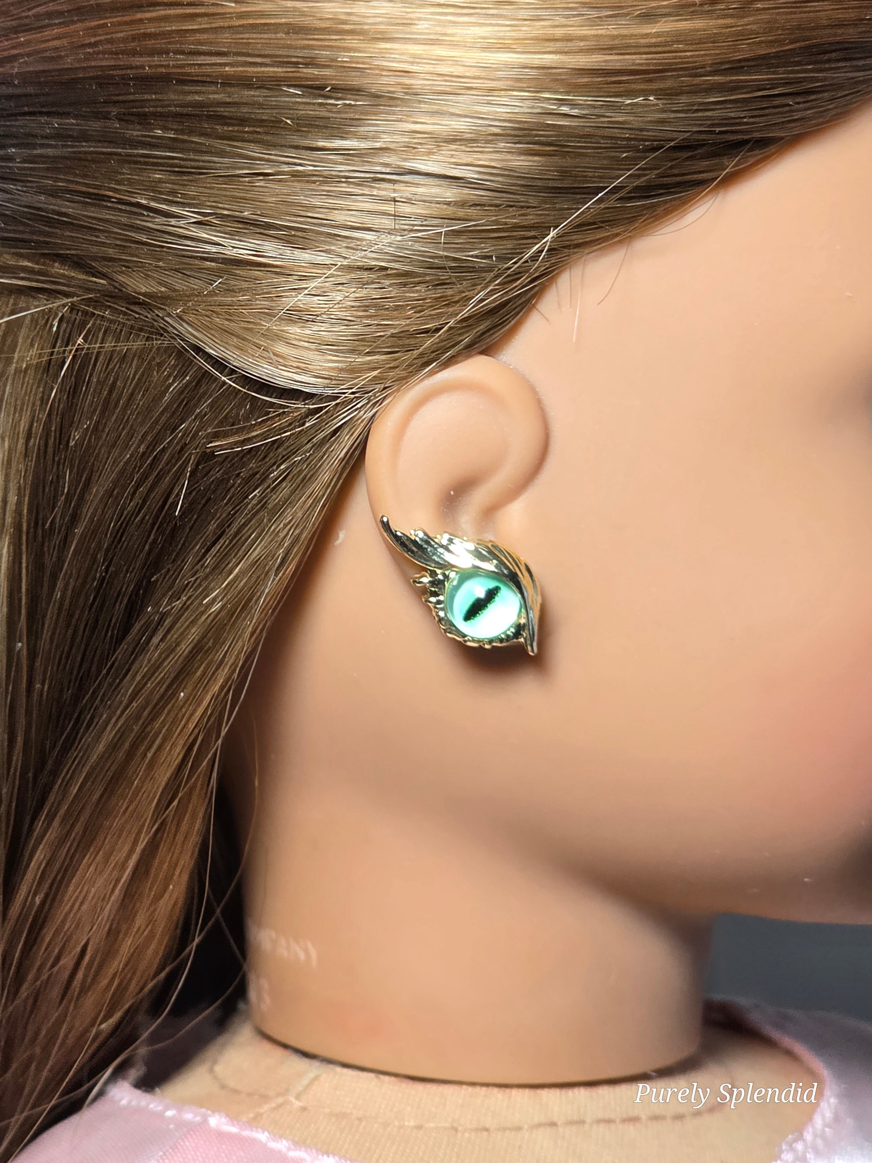 18 inch doll wearing a pair of green eye studs