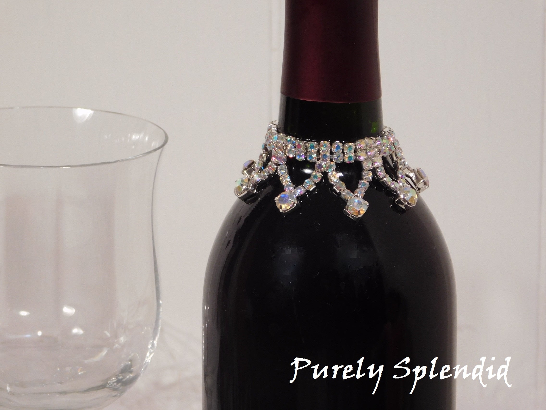 close up of the Sparkling Aurora Borealis Wine Bottle Bling Necklace on a standard size wine bottle, reusable