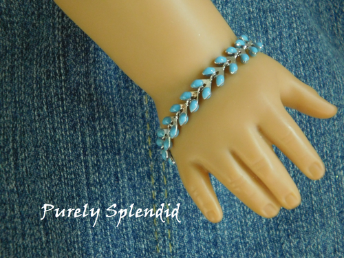 Baby Blue and silver colored bracelet shown on an 18 inch doll who has a 3 1/4
