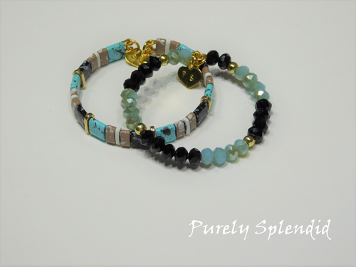 two black and blue colored stacking bracelets one with flat beads and the other with shaped crystals