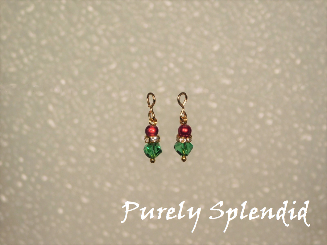 Green crystal bead topped with a ring of golden sparkles and a cherry red pearl.