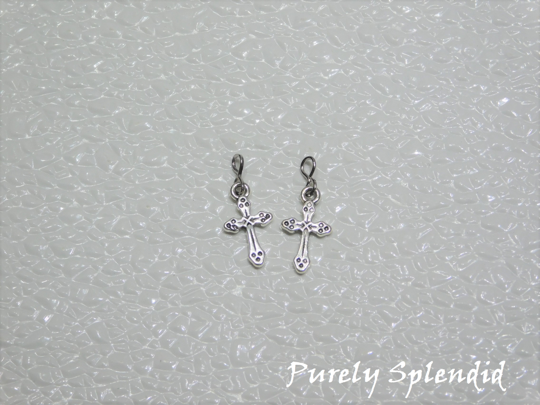 silver colored Cross earrings on a white background 