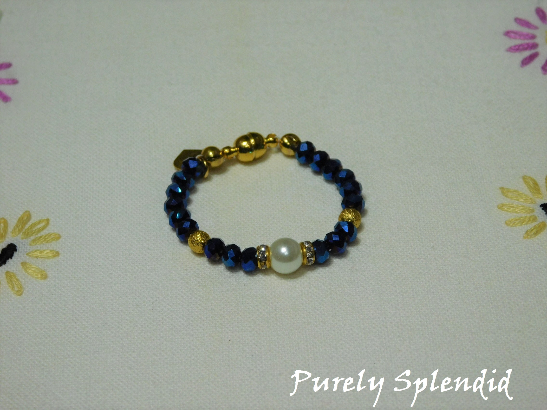 Beautiful Sapphire Blue Crystal beads make this Crystal Evening Bracelet look lovely! A large white pearl flanked by a ring of sparkle is the focal point.