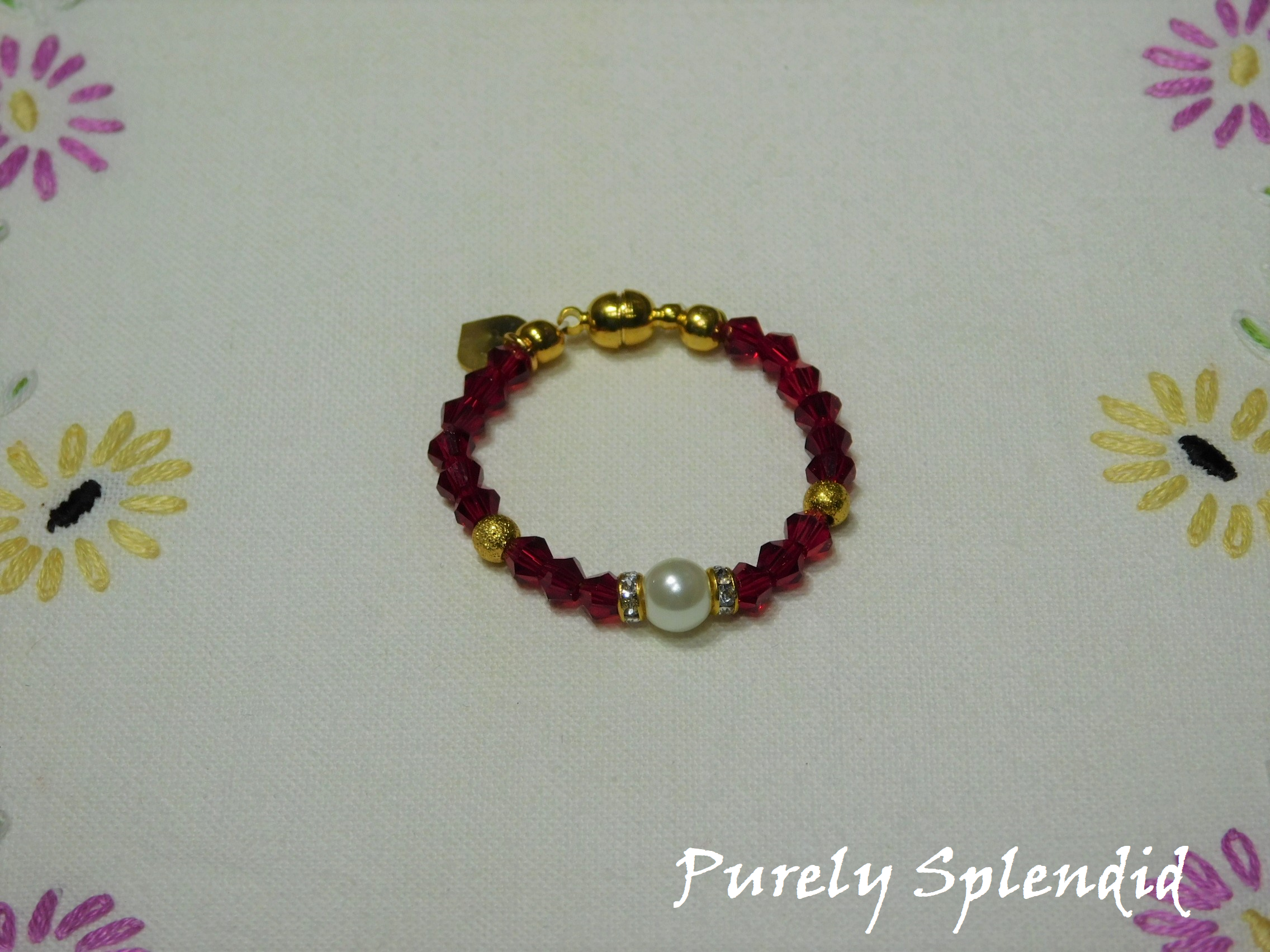 Beautiful Ruby Red Crystal beads make this Crystal Evening Bracelet look lovely! A large white pearl flanked by a ring of sparkle is the focal point.