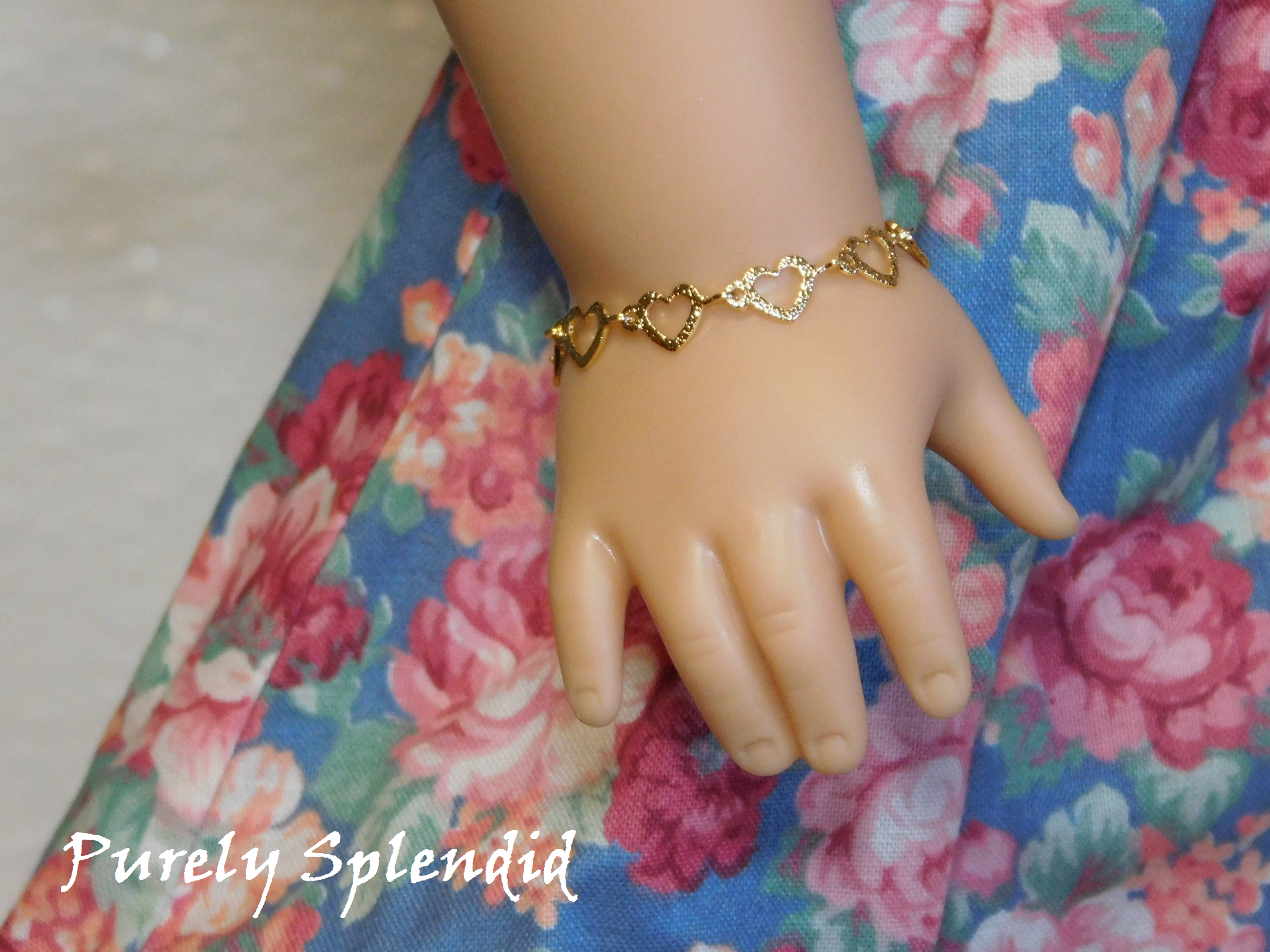 Golden open hearts make up this Dainty Gold Heart Bracelet. Shown worn by an 18 inch doll