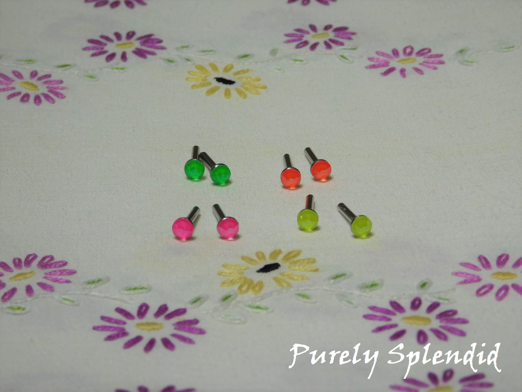 4 pairs of 2mm studs, Electric Yellow, Electric Orange, Electric Pink and Electric Green on a white floral background