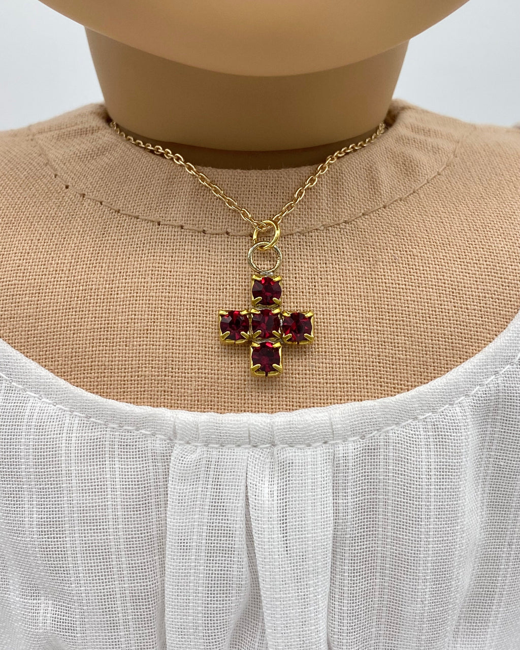 18 inch doll wearing a sparkling red cross necklace