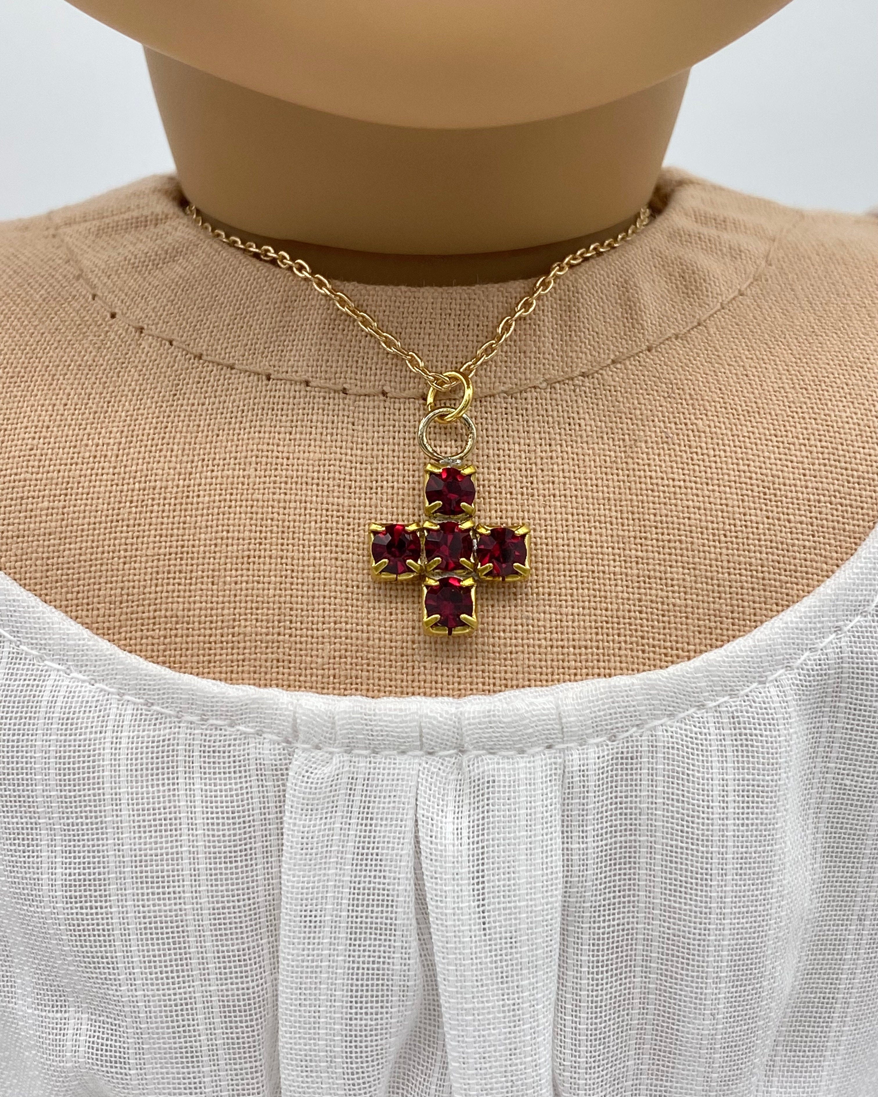 18 inch doll wearing a sparkling red cross necklace