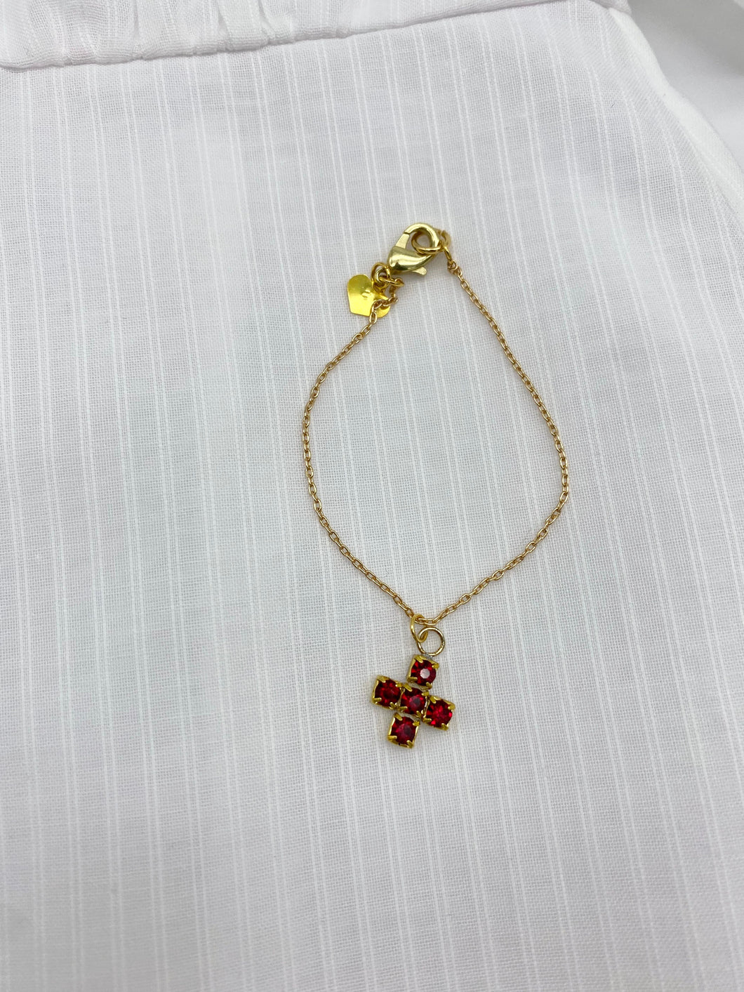 red cross necklace on a white background