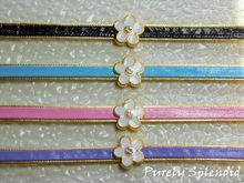 Load image into Gallery viewer, Four pretty Flower Choker Necklaces on a white background - black, blue, pink and purple leather like choker with a gold rimmed white enamel flower with sparkling center
