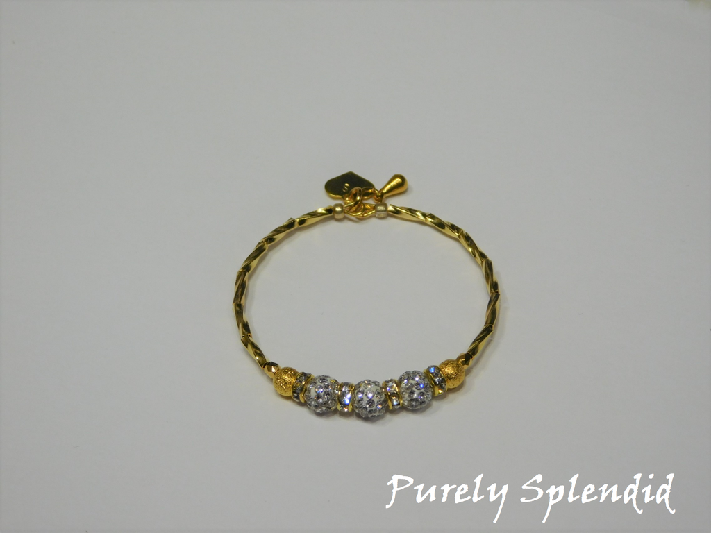 Gold bracelet with three round sparkling silver beads each surrounded with a ring of sparkle