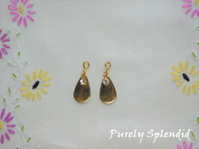 Load image into Gallery viewer, Golden Drop Earrings shown on a white floral background

