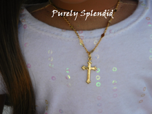 Load image into Gallery viewer, decorative gold cross on a decorative gold chain shown worn by an 18 inch doll
