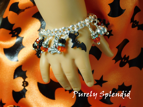 Halloween Charm Bracelet with pumpkin, bat, flying witch and sparkling charms shown on an American Girl Doll