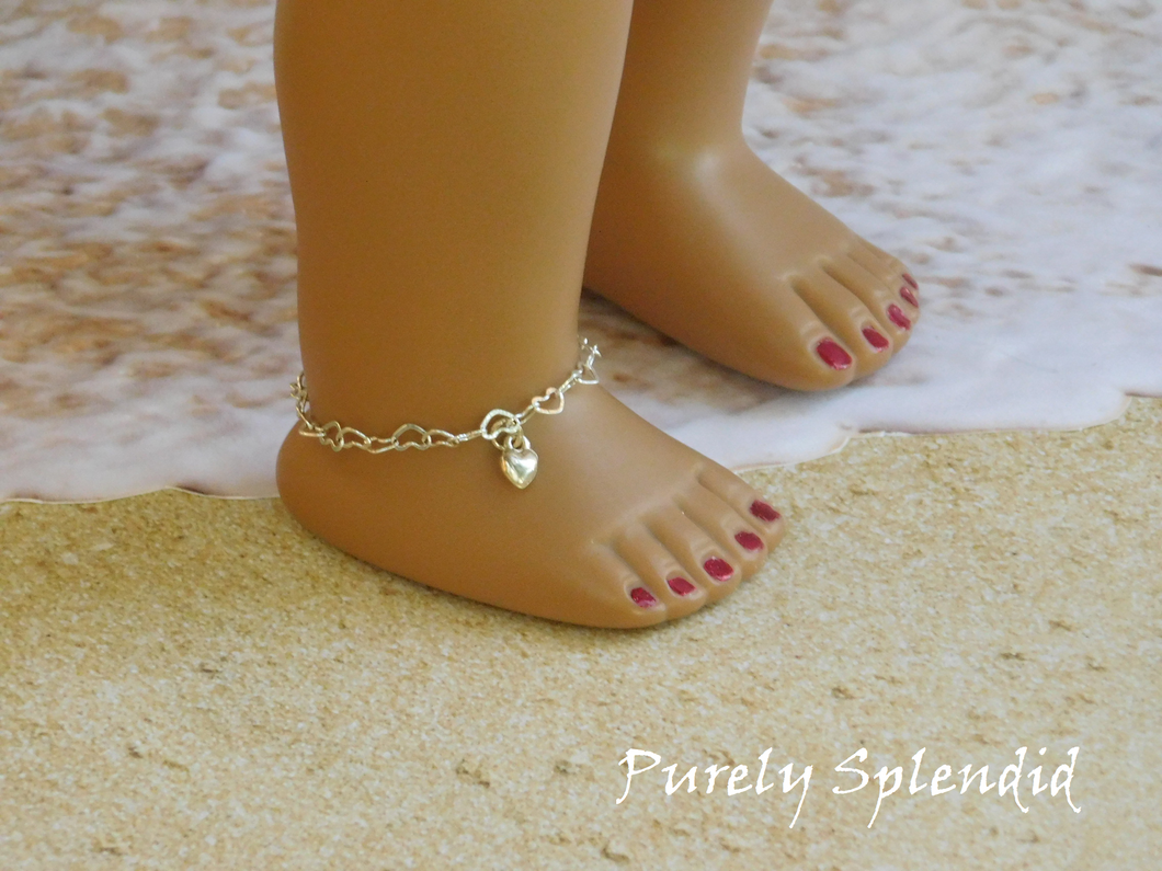 Dainty silver heart chain with one silver heart charm shown on the ankle of an 18