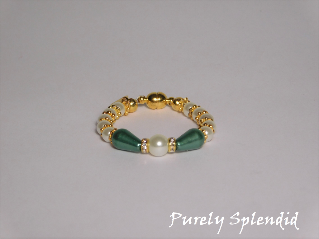 round white pearls with gold spacer beads with the main focus made up of one large white pearl bead surrounded by a thin sparkling bead and green pear shaped pearl 