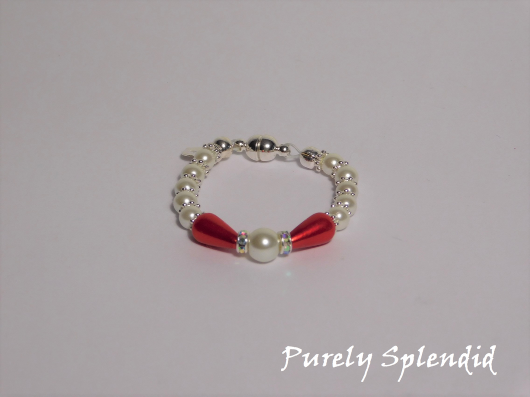 round white pearls with silver spacer beads with the main focus made up of one large white pearl bead surrounded by a thin sparkling bead and red pear shaped pearl 