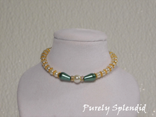 Load image into Gallery viewer, one large round white pearl surrounded by a thin sparkling bead and green pear shaped pearl bead. The rest of the necklace is made up with round white pearls alternating with gold spacer beads
