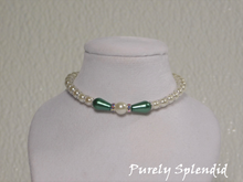 Load image into Gallery viewer, one large round white pearl surrounded by a thin sparkling bead and green pear shaped pearl bead. The rest of the necklace is made up with round white pearls alternating with silver spacer beads
