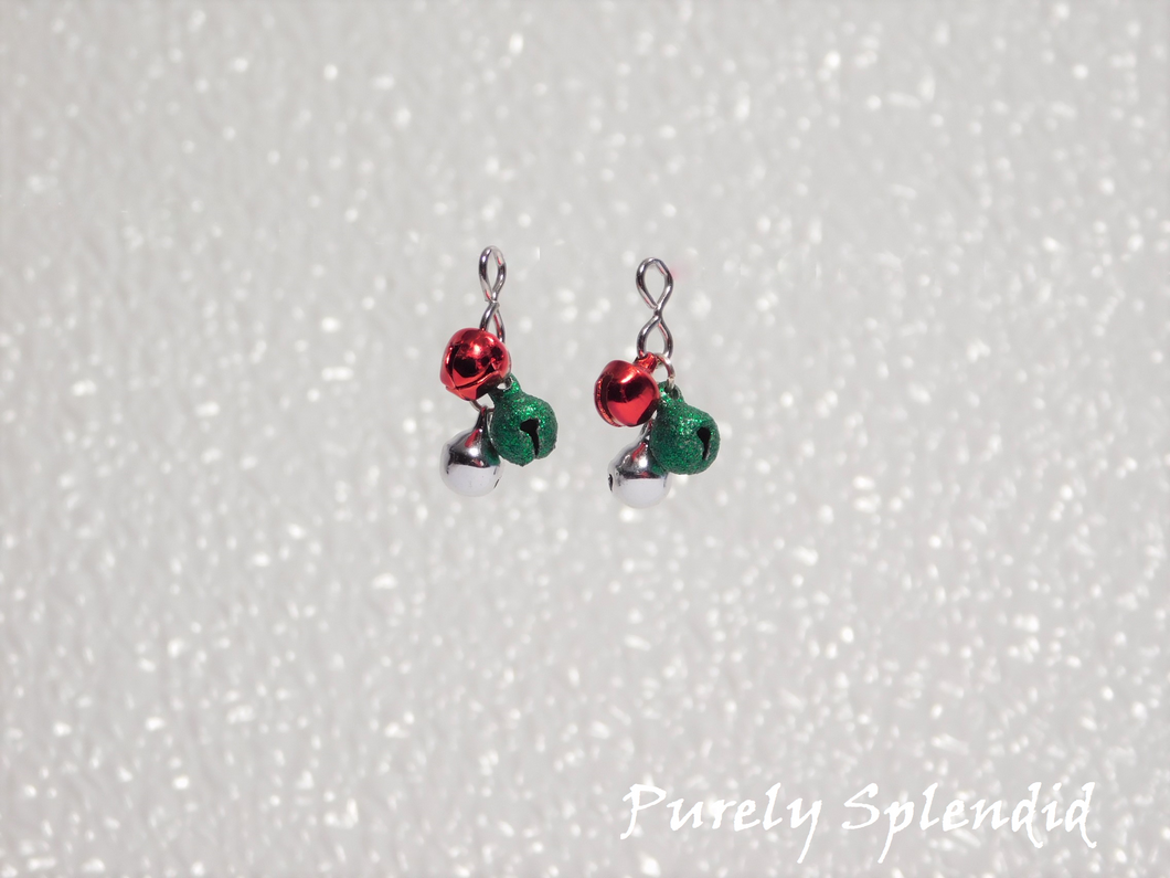 Three small jingle bells, one red, one green glitter and one silver hanging from the earring attachment
