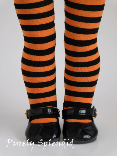 Orange and Black Striped Tights shown on an 18 inch doll who is also wearing a pair of  black shoes. Tights are a perfect fit hugging her legs