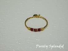Load image into Gallery viewer, Gold bracelet with three round sparkling red beads each surrounded with a ring of sparkle
