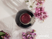 Load image into Gallery viewer, overhead view of the Sparkling Rhinestone Flower Bottle Bling on a standard size wine bottle

