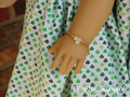 18 inch doll shown wearing a Sparkling Golden Shamrock on a gold colored chain