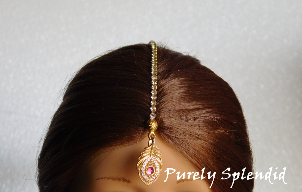 Beautiful Golden Peacock Feather with sparkling pink center stone surrounded with crystals. A sparkling hair chain hooks into the hair 