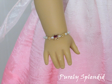 Load image into Gallery viewer, Dainty pearl like beaded chain with a focal point of a cubic zirconia red and crystal pendant shown on an 18 inch doll
