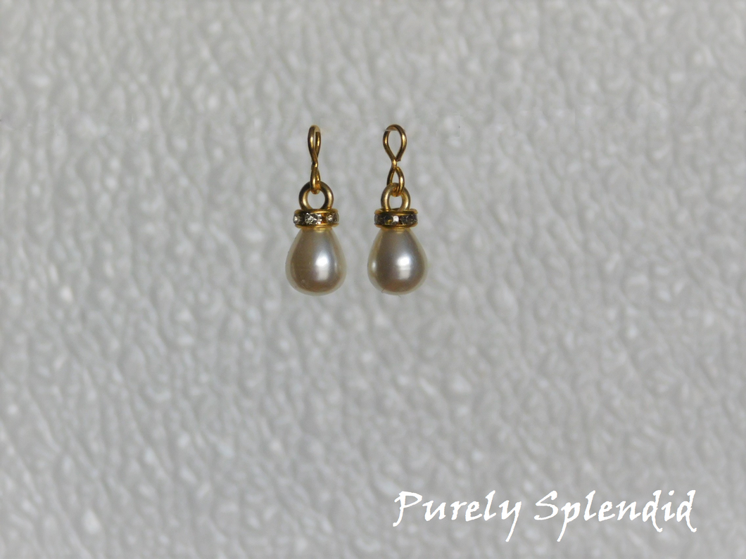 Large white pearl drop earrings with a gold sparkling ring around the top