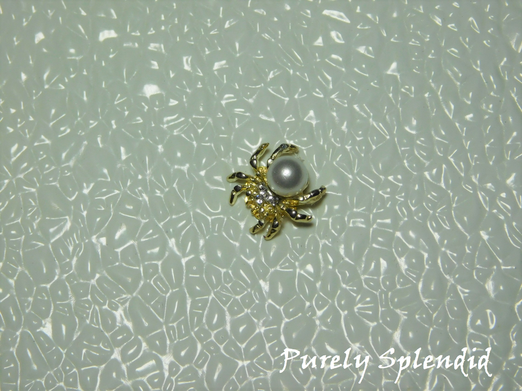 A large faux pearl is the body of this Spider Brooch
