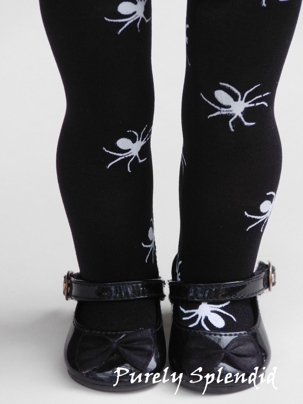 18 inch doll shown wearing a pair of Black Tights with white spiders.