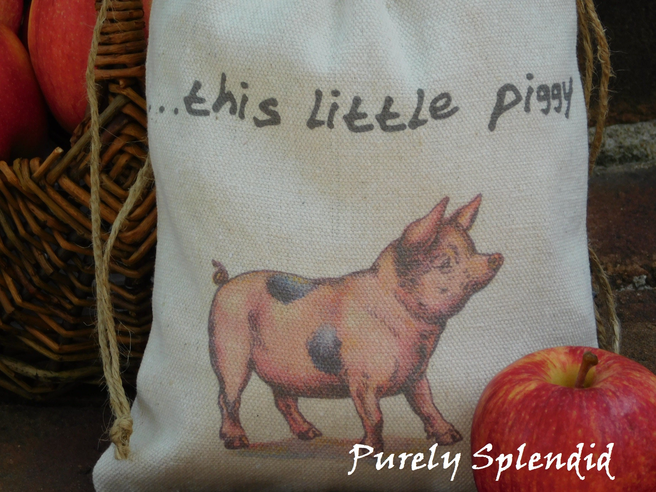 close up picture of a vintage style pink pig fabric bag with the words ...this little piggy