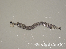 Load image into Gallery viewer, Three rows of silver colored rhinestones make up this Triple Silver Rhinestone Bracelet. Closes with a magnetic clasp. Shown laying on a white background
